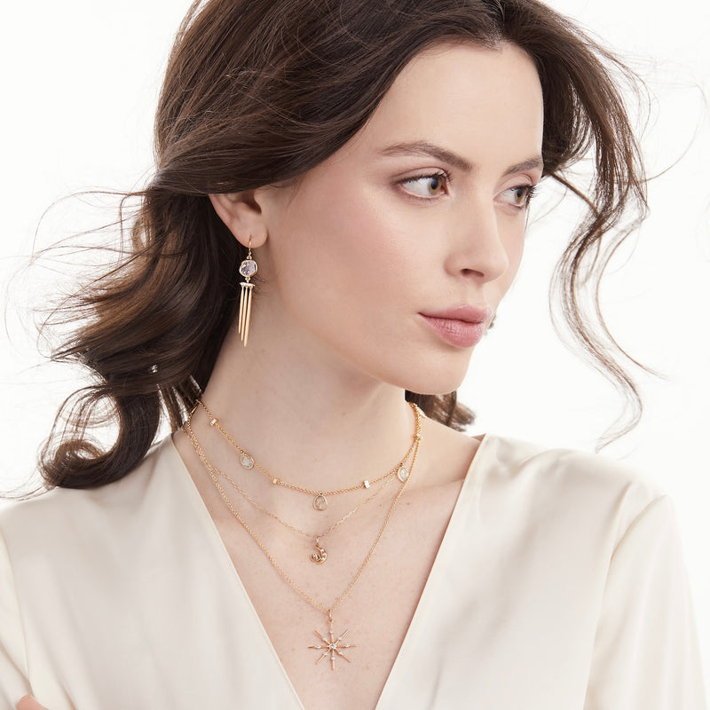 Model wearing 14K gold star pendant with diamonds and diamond slice jewelry