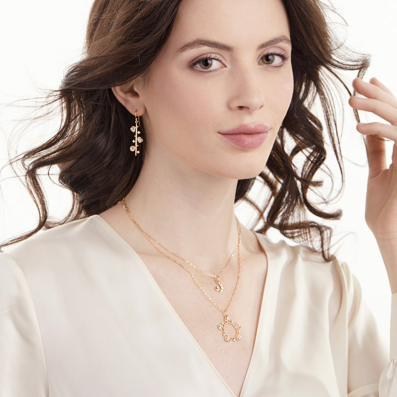 Model wearing 14K gold linear earrings with diamond slices and diamond slice necklaces