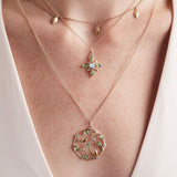 Model wearing  layered pendants with 14K gold leaves and green tourmaline