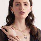Model wearing black enamel heart necklace with black enamel and diamond heart pendant