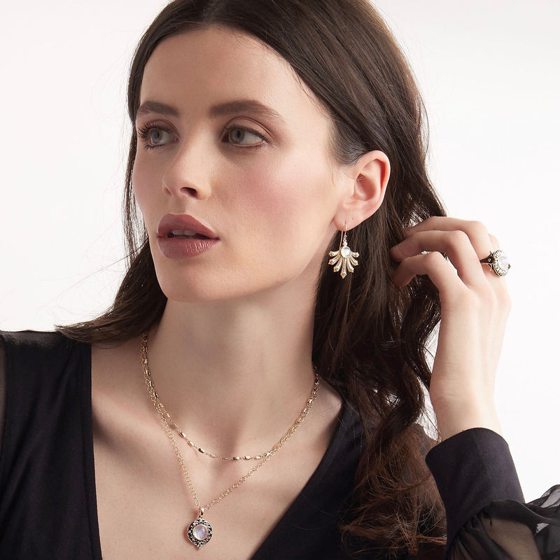Model wearing Catalina fan earrings in 14K gold with diamonds