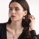 Model wearing moonstone and black enamel scrolled pendant