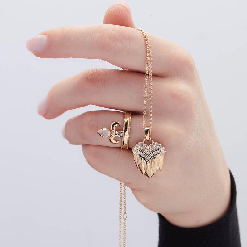 Model holding heart pendant in 14k gold with diamonds